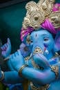 Vibrant depiction of Lord Ganesha statue adorned with gold and bright colors for the Ganesh Chaturthi festival.